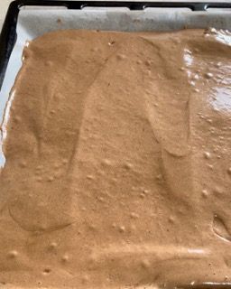 Un vassoio di impasto per torta al cioccolato è appoggiato su un tavolo.