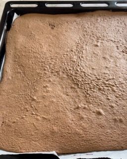 Un pezzo di torta al cioccolato è appoggiato su una teglia.