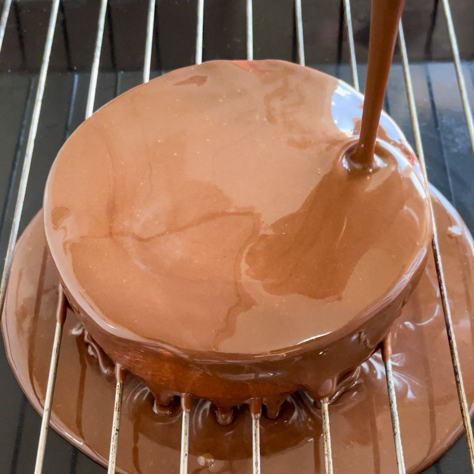 Una torta al cioccolato viene versata su una griglia di raffreddamento