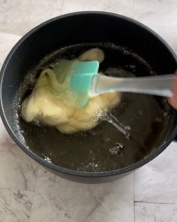 Una persona sta mescolando una pentola di liquido con una spatola