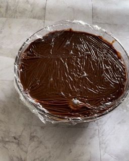 Una ciotola di budino al cioccolato avvolta nella pellicola trasparente