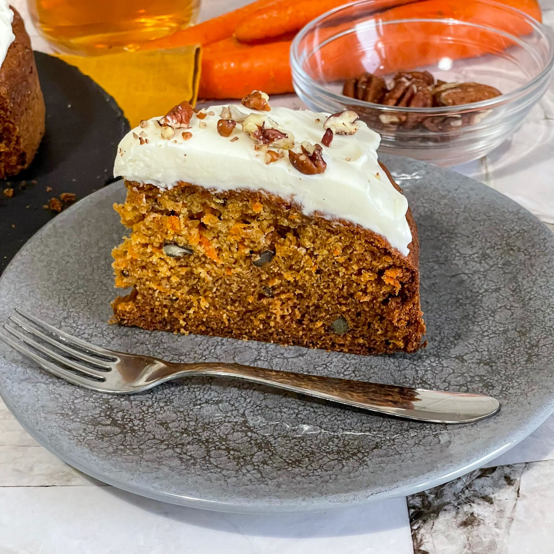 Una fetta di torta di carote su un piatto con una forchetta