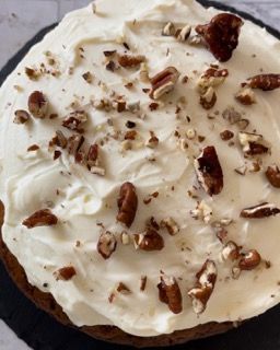 Una torta con glassa bianca e noci pecan sopra