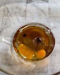 Un uovo rotto è in una ciotola di liquido