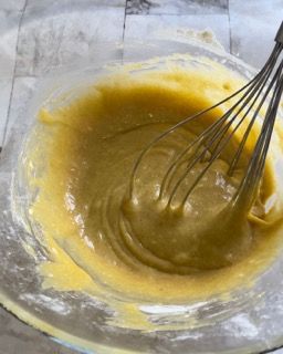 Una frusta è in una ciotola di liquido giallo.