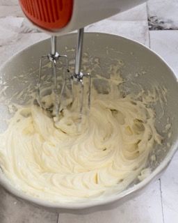 Una ciotola di panna montata con dentro un mixer