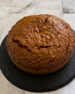 Una torta marrone è appoggiata su un piatto nero