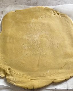 Un grosso pezzo di pasta è appoggiato su un foglio di carta oleata.