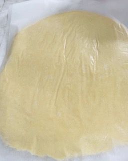 Un grosso pezzo di pasta è appoggiato su un foglio di carta oleata.