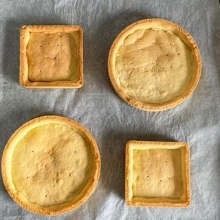 Quattro pasticcini di forma diversa sono su un pezzo di carta oleata