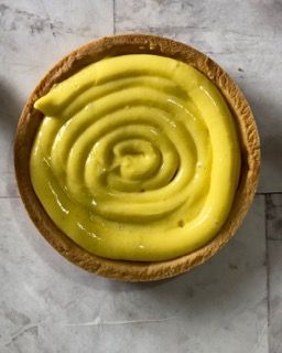 Una piccola torta con una spirale di glassa gialla sopra