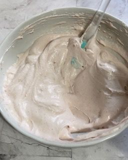 Una ciotola di panna montata con un cucchiaio dentro.