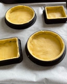 Un vassoio con quattro cerchi e quattro quadrati di pasta sopra