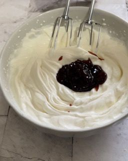 Una ciotola di panna montata con un cucchiaio dentro