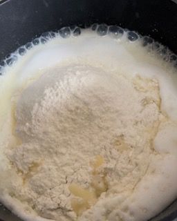 Primo piano di una pentola piena di farina e latte.