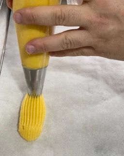 Una persona sta versando la glassa gialla in una sac à poche