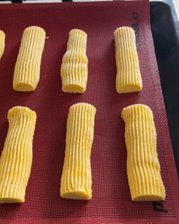 Un mazzo di bastoncini gialli su un tappetino rosso con la scritta KitchenAid