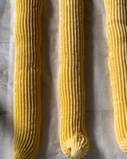 Tre tubetti di glassa gialla sono appoggiati su un tavolo.