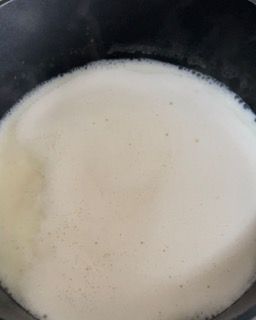 Primo piano di una pentola piena di liquido bianco.