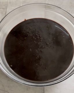 Una ciotola di salsa al cioccolato è appoggiata su un tavolo.