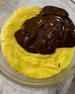 Una ciotola di vetro piena di salsa gialla e al cioccolato