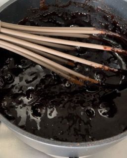 Una pentola di salsa al cioccolato con una frusta dentro