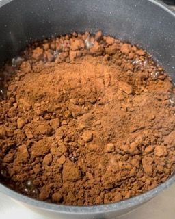 Una pentola piena di polvere marrone e liquido