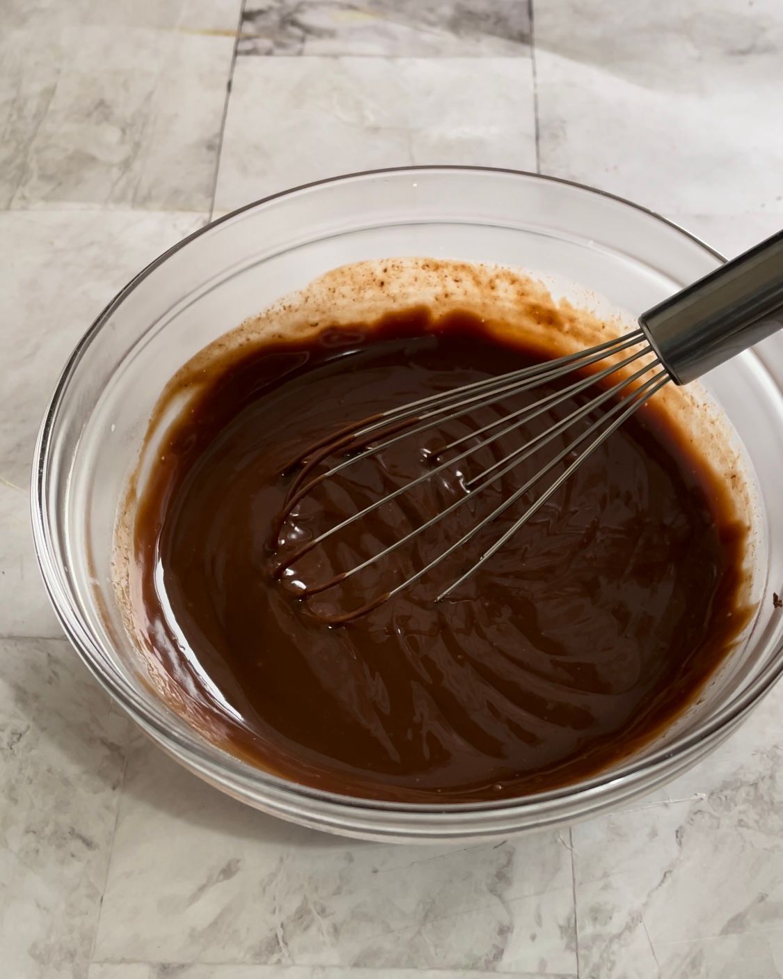 Una ciotola di salsa al cioccolato con una frusta dentro