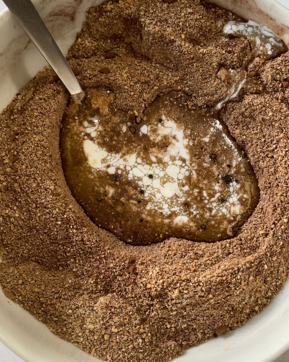 Un primo piano di una ciotola di cibo con un cucchiaio dentro.