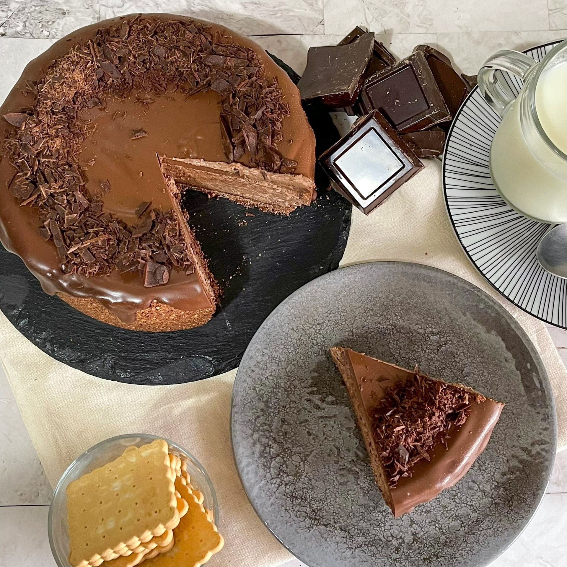 Su un tavolo c'è una torta al cioccolato da cui è stata staccata una fetta.