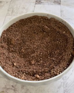 Mix di polveri in una ciotola: farina di mandorle, nocciole, cacao e fecola.