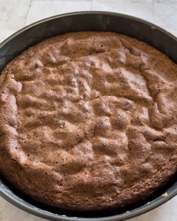 Torta Caprese appena sfornata che si intiepidisce nello stampo.