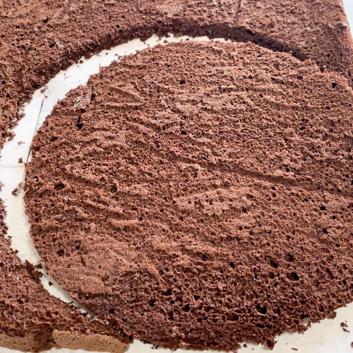 Un primo piano di una torta al cioccolato con un cerchio ritagliato.