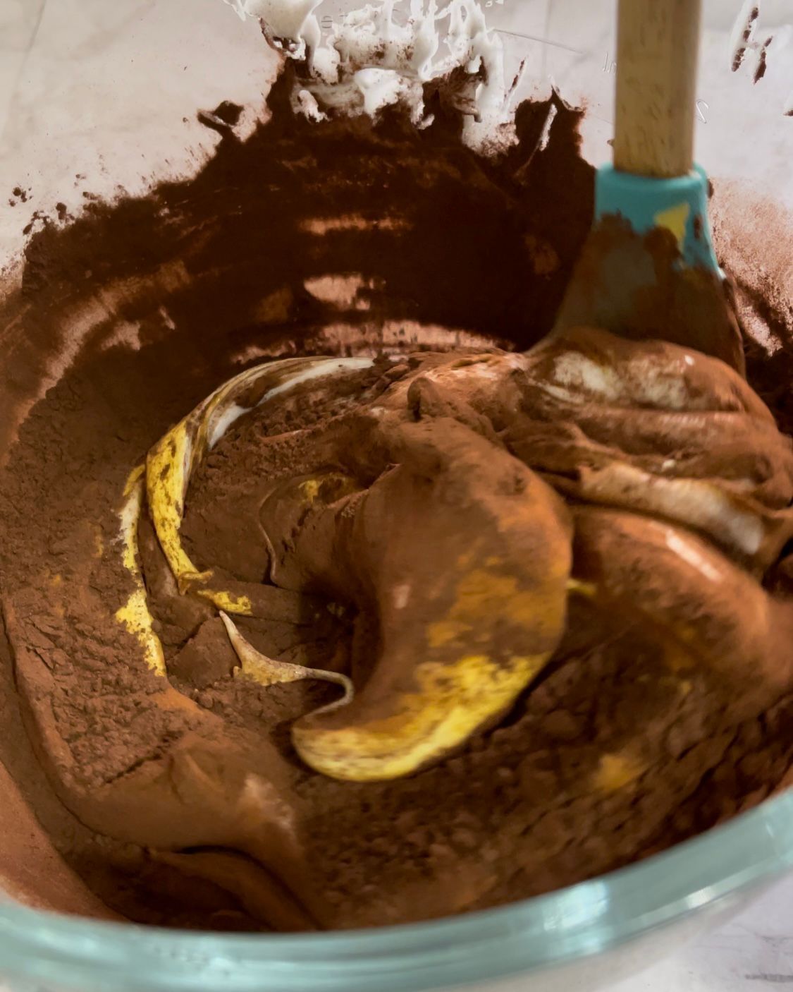 Una ciotola di impasto per torta al cioccolato con una spatola dentro