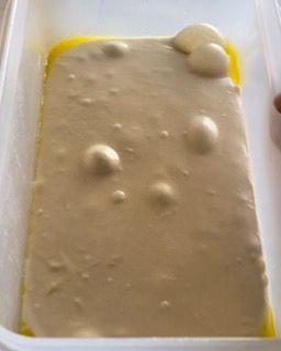 Un contenitore bianco riempito con una sostanza bianca contenente delle bolle.