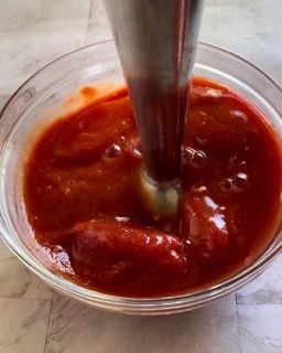 Una ciotola di salsa di pomodoro con un frullatore dentro