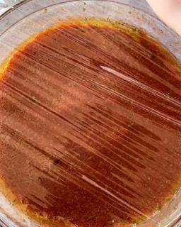 Primo piano di una ciotola di zuppa ricoperta di pellicola trasparente.