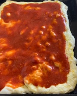 Una pizza con sopra il sugo di pomodoro