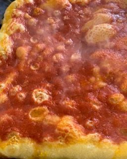 Un primo piano di una pizza con salsa di pomodoro.
