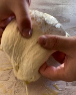 Una persona tiene in mano un pezzo di pasta.