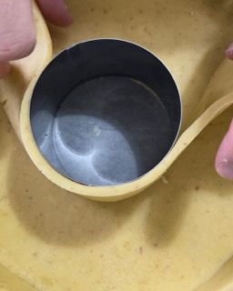 Una persona tiene in mano un misurino sopra una ciotola di cibo.