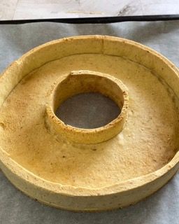 Una pasta per torta con un buco nel mezzo è appoggiata su un tavolo.