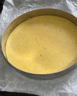 Una padella rotonda piena di liquido giallo è appoggiata su un pezzo di carta oleata.