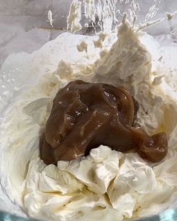 Un primo piano di una ciotola di panna montata e salsa al caramello