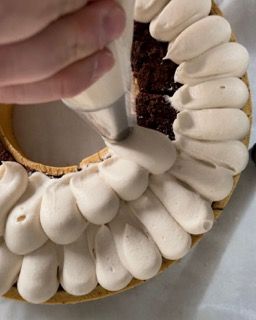 Una persona sta glassando una torta con una sac à poche