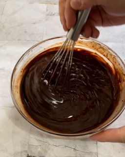 Una persona sta mescolando una ciotola di salsa al cioccolato