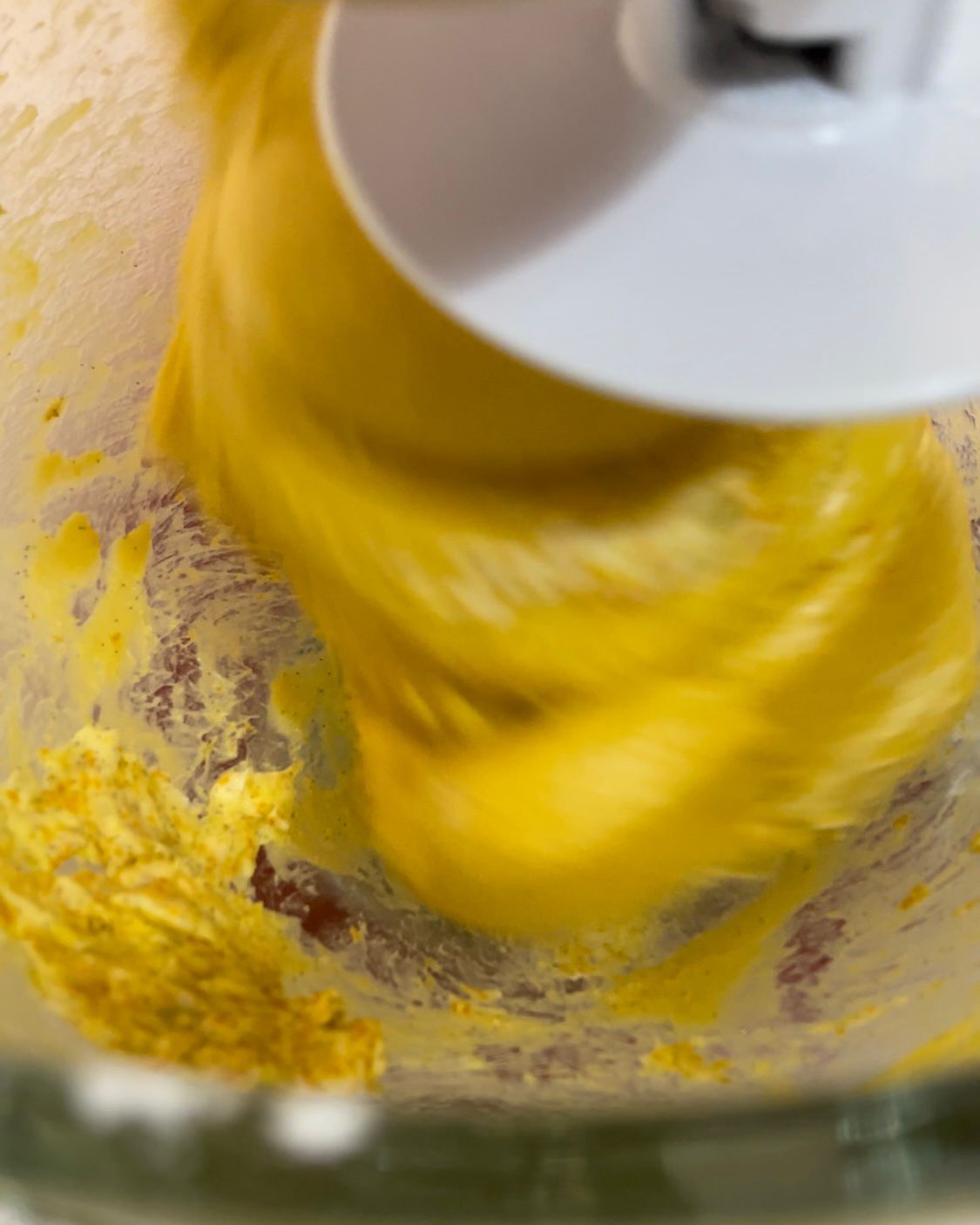 Un primo piano di un frullatore con del liquido giallo al suo interno