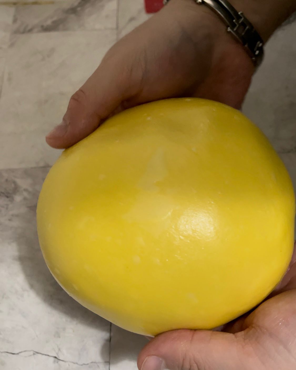 Una persona tiene in mano una grande palla gialla