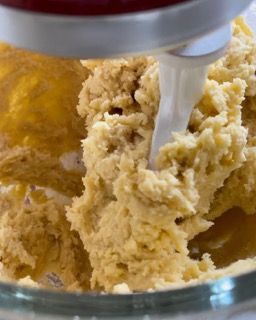 Un mixer sta mescolando un impasto in una ciotola di vetro.