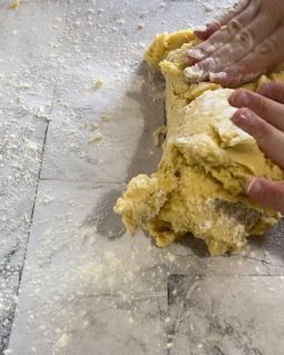 Una persona sta impastando l'impasto su una superficie di marmo.